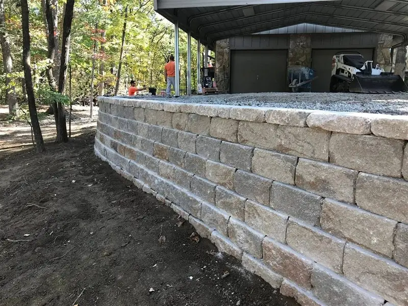 MB General Contracting crew building a retaining wall with a skid steer in Phelps County, MO